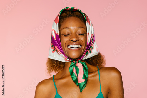 Happy woman with closed eyes and colorful scarf on head photo