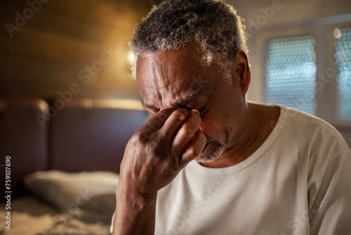 Senior man with a headache at home