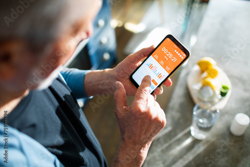 Elderly man checking health app on smartphone for fitness tracking photo