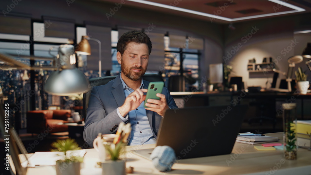 Smiling ceo typing phone message in evening office closeup. Happy man joyful Smiling ceo typing phone message in evening office closeup. Happy man joyful
