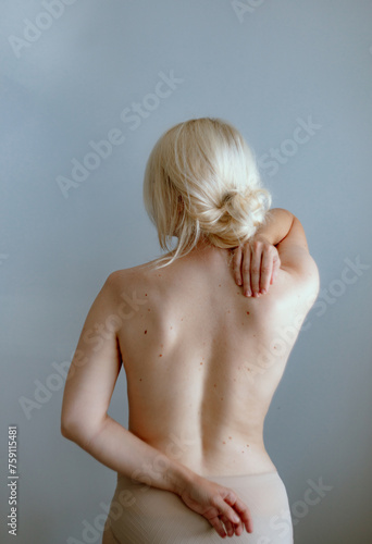 Detail of a woman's naked back with her hands on her back