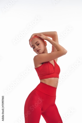 Elegant woman in sportswear touching her head with her eyes closed