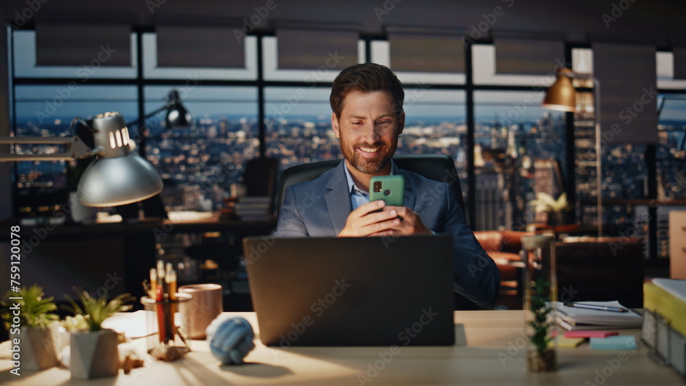 Happy boss relaxing cellphone late office closeup. Positive businessman smiling Happy boss relaxing cellphone late office closeup. Positive businessman smiling