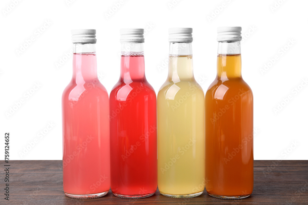 Delicious kombucha in glass bottles on wooden table against white background
