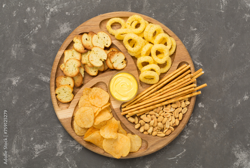 Different tasty snacks on concrete background, top view Different tasty snacks on concrete background, top view