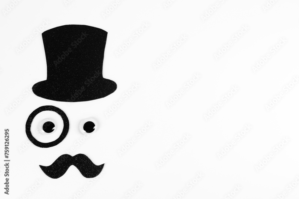 Man's face made of fake mustache, hat, eyes and monocle on white background, top view. Space for text