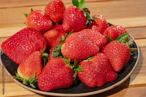 New harvest, plate with bio ripe red sweet strawberry from Spain