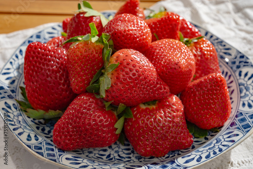 New harvest, plate with bio ripe red sweet strawberry from Spain