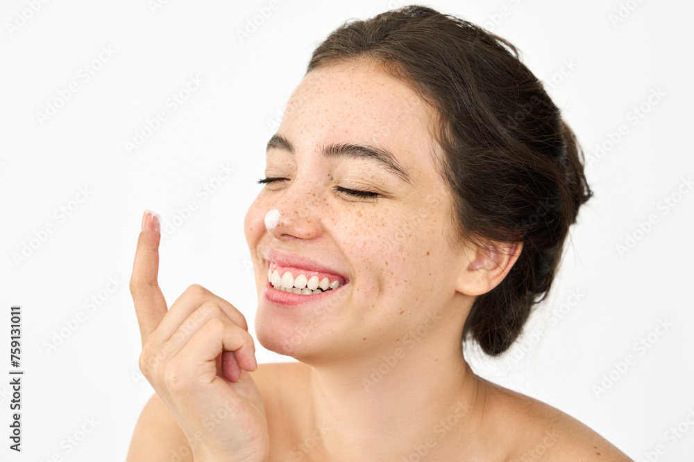 Happy Latin girl, young woman model freckles on face having fun applying sunscreen moisturizer cream on nose for healthy fresh skin care isolated on white background, skincare treatment, close up. Happy Latin girl, young woman model freckles on face having fun applying sunscreen moisturizer cream on nose for healthy fresh skin care isolated on white background, skincare treatment, close up.