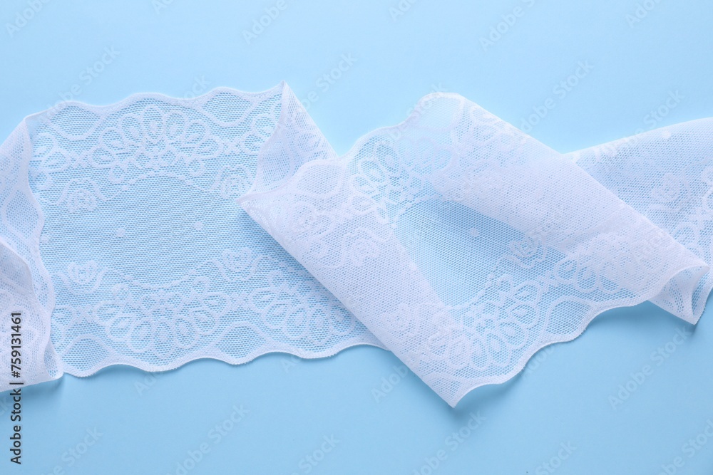 Obraz premium White lace on light blue background, top view