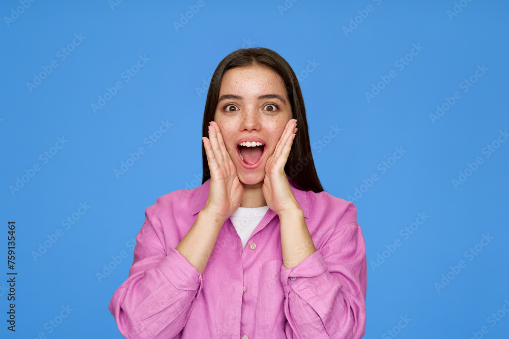 Excited pretty cool gen z surprised Latin customer teenage girl with wow face expression feeling amazed advertising promotion on blue background. Shopping offer surprise concept. Excited pretty cool gen z surprised Latin customer teenage girl with wow face expression feeling amazed advertising promotion on blue background. Shopping offer surprise concept.