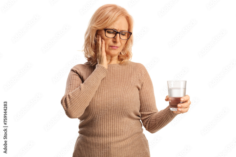 Middle aged woman holding a glass of water and having a toothache Middle aged woman holding a glass of water and having a toothache