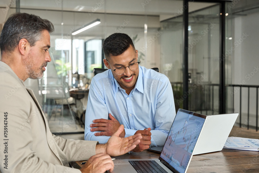 Two busy happy business men doing trading data forecast. Male advisor analyst consulting investor about stock market financial investing in crypto exchange using laptop computer working in office. Two busy happy business men doing trading data forecast. Male advisor analyst consulting investor about stock market financial investing in crypto exchange using laptop computer working in office.