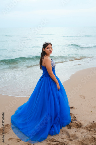 Latina girl in Quinceañera gown posing in the beach photo