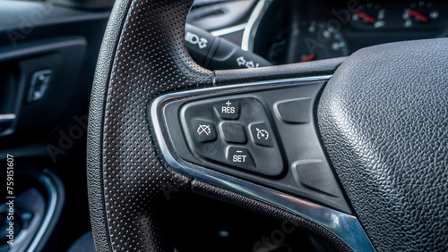 cruise control buttons on the steering wheel in a new car © AvokadoStudio
