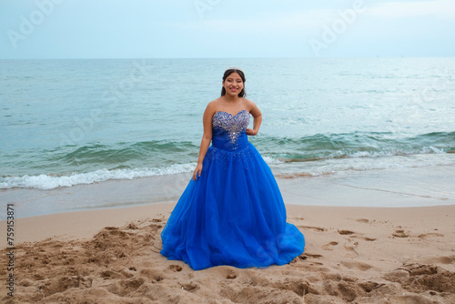 Latina girl in Quinceañera gown posing in the beach