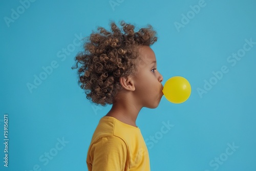 African american child boy blowing up bubble with chewing gum on blue background