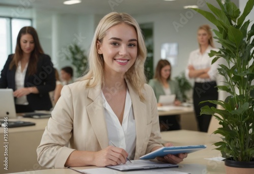 A blonde businesswoman holds documents, standing by a plant. An office meeting is in the background.