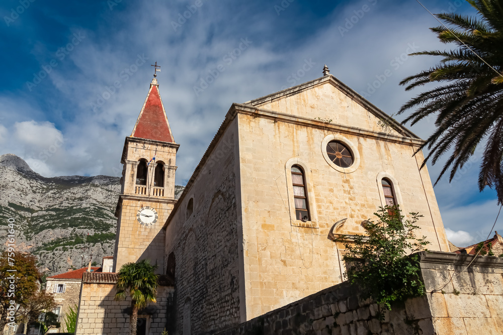 Scenic view of St. Mark church on Kacic square coastal town Makarska, Split-Dalmatia, Croatia, Europe. Biokovo mountain range background, Dinaric Alps. Travel destination summer. Riviera Adriatic Sea