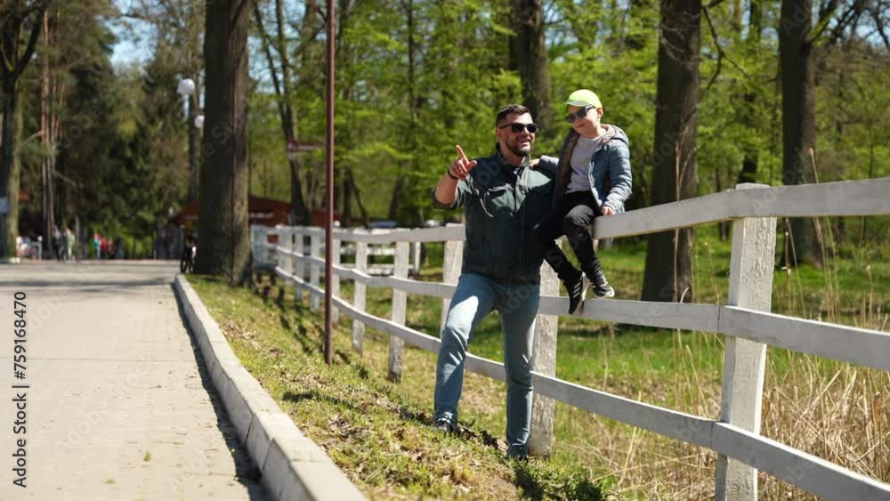 Father and Son Enjoying a Sunny Day at the Park. A joyful stroll with dad in the park. Concept Family Bonding Father and Son Enjoying a Sunny Day at the Park. A joyful stroll with dad in the park. Concept Family Bonding