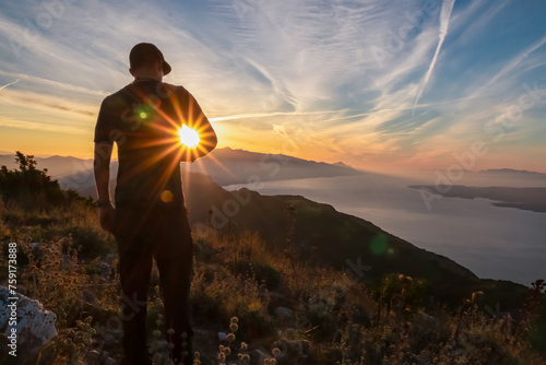 Hiker man with scenic sunrise view from top of mount Kula near Omis, Dinara mountains, Split-Dalmatia, Croatia, Europe. Coastline of Makarska Riviera, Adriatic Sea. Balkans in summer. Biokovo mountain © Chris