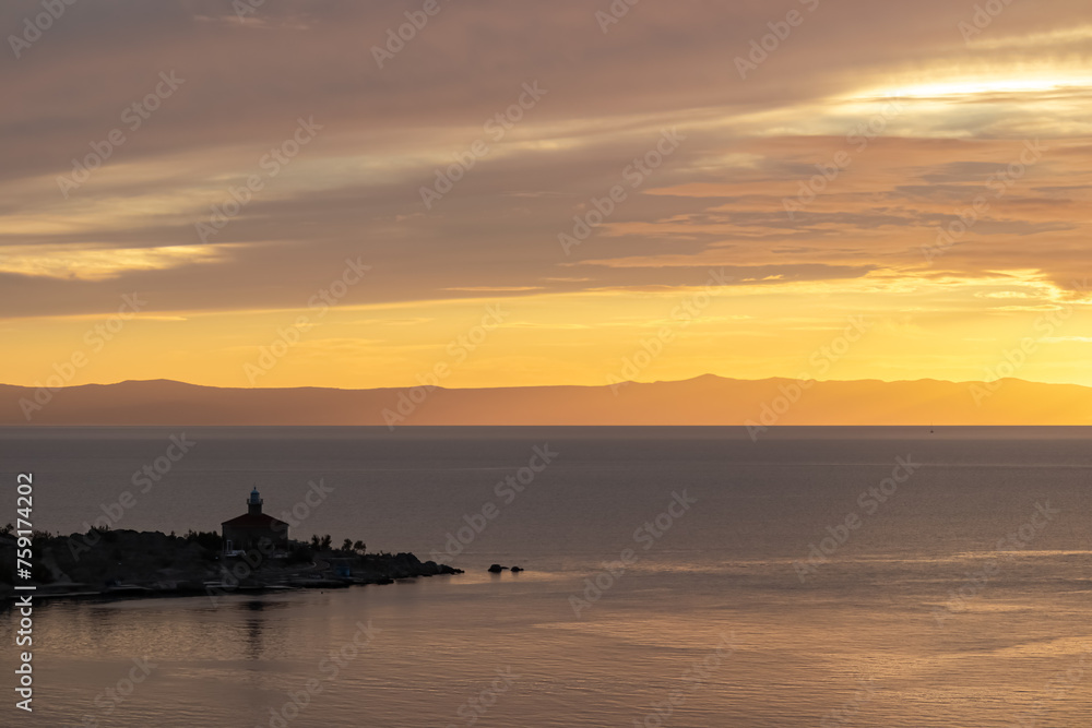 Aerial sunset view of Dalmatian archipelago seen from coastal town Makarska, Split-Dalmatia, Croatia, Europe. Silhouette of lighthouse. Coastline of Makarska Riviera, Adriatic Sea. Balkans in summer