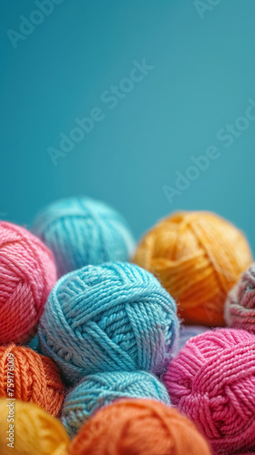 Colorful balls of yarn on blue background with copy space, collection of colors woolen skeins for knitting thread