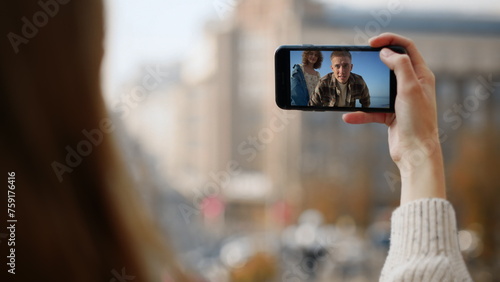 Happy friends waving smartphone on trip. Closeup hand hold mobile phone at city