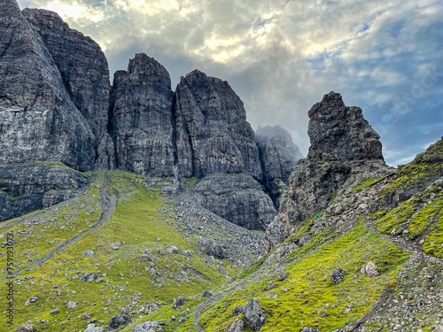 Majestic steep rocky cliffs of The Storr mountain towering above grassy slopes