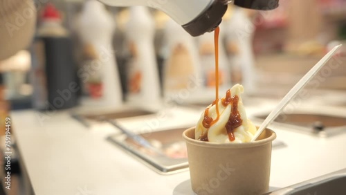 Caramel sauce pouring on vanilla ice-cream