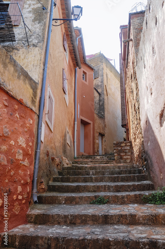 Narrow alley in historic Roussillon town in France © Fotokon
