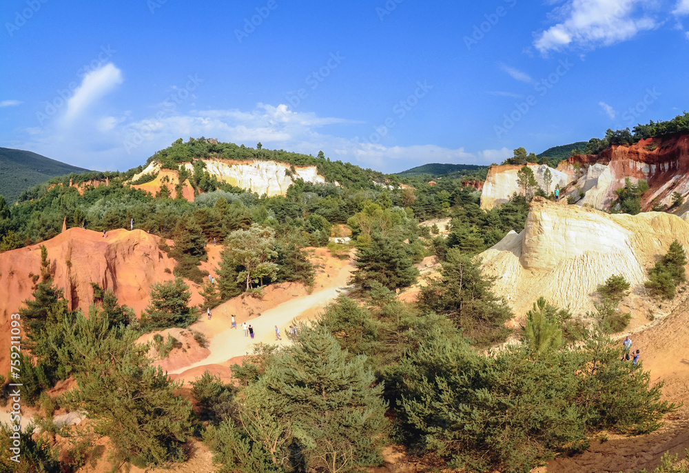 Tourists on Ochre trail called Provencal Colorado in Rustrel town, Provence, France