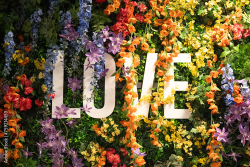 Schriftzug  LOVE  umh  llt von bunten Blumen