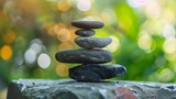 Zen stones stacked in balance in a peaceful nature setting. Wellness and meditation concept. Bokeh background with copy space for design and print