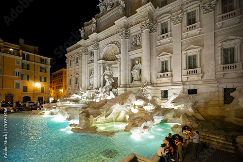 Evening view of an illuminated Trevi Fountain in Piazza di Trevi in the historic Centro Storico of Rome, Italy.