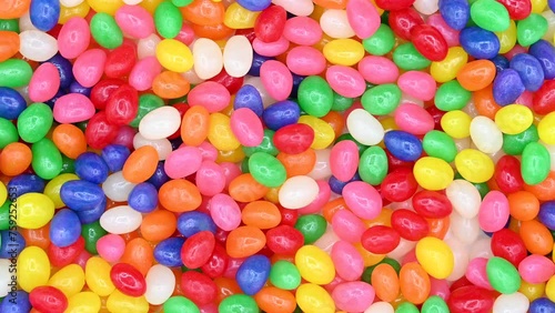 4K HD video of background of bright vibrant colorful jelly beans, wood spoon comes in and scoops up some candy.
 photo