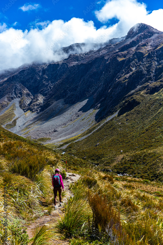 backpacker enjoys a scenic trail in otira valley, panorama of mountains in arthur's pass national park, canterbury, new zealand south island backpacker enjoys a scenic trail in otira valley, panorama of mountains in arthur's pass national park, canterbury, new zealand south island