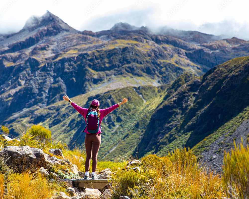happy backpacker spreads arms enjoying the panorama of otira valley in new zealand happy backpacker spreads arms enjoying the panorama of otira valley in new zealand