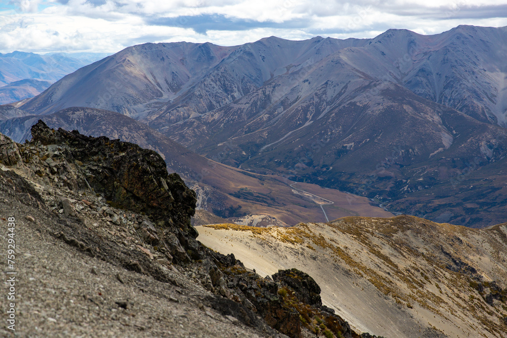Rugged, rocky landscape of mountain ranges in Torlesse Tussocklands Park. Track to Castle Hill Peak, near Sheffield, Canterbury, new zealand south island. Mountains close to Christchurch. Mordor scene Rugged, rocky landscape of mountain ranges in Torlesse Tussocklands Park. Track to Castle Hill Peak, near Sheffield, Canterbury, new zealand south island. Mountains close to Christchurch. Mordor scene