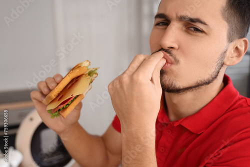 Young man with tasty sandwi...