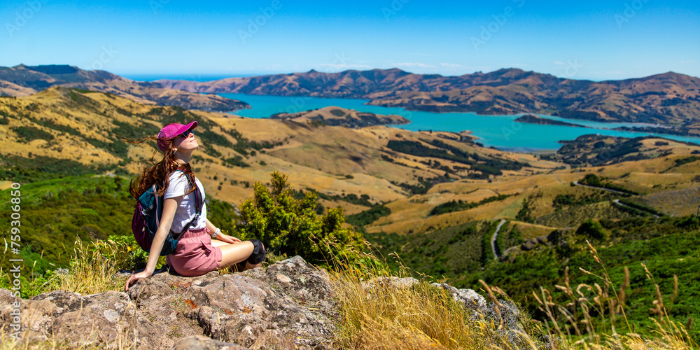 hiker girl admires the panorama of akaroa harbour and banks peninsula from the otepatotu scenic reserve, canterbury, new zealand south island near christchurch hiker girl admires the panorama of akaroa harbour and banks peninsula from the otepatotu scenic reserve, canterbury, new zealand south island near christchurch