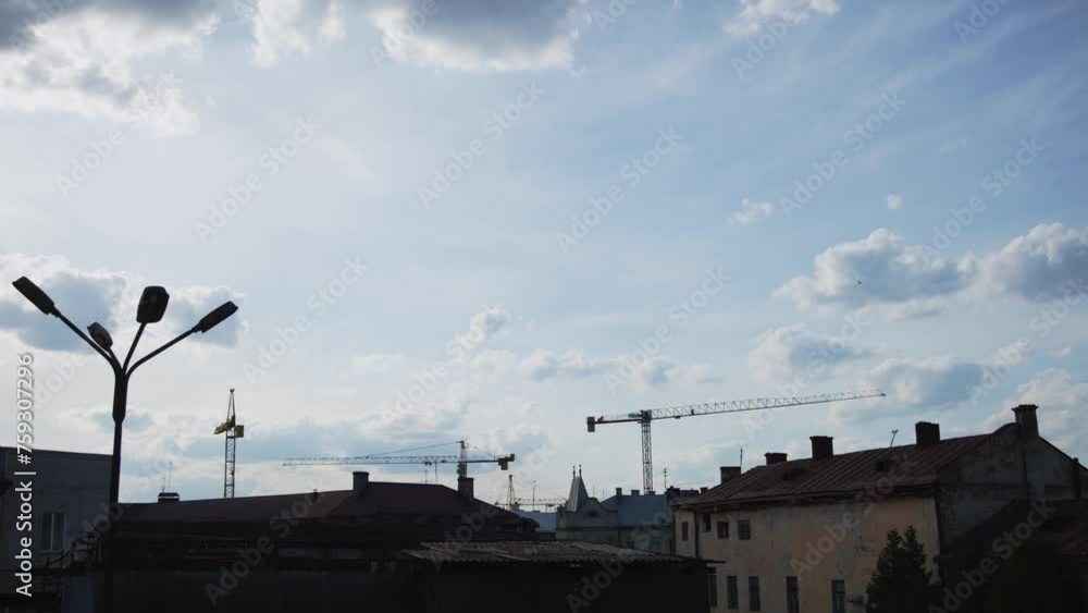 A serene daytime sky with towering construction cranes marking progress and change. A serene daytime sky with towering construction cranes marking progress and change.