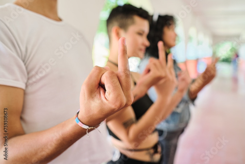Group of people making fuck you gestures with their hands.