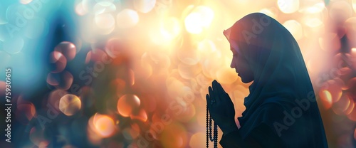 Silhouette of a Muslim woman holding a rosary and praying with a blurred natural background for a religious photo