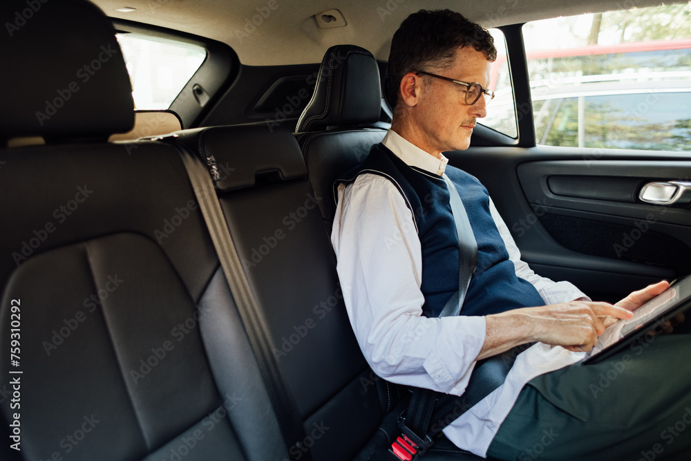 Man working on tablet in car Man working on tablet in car