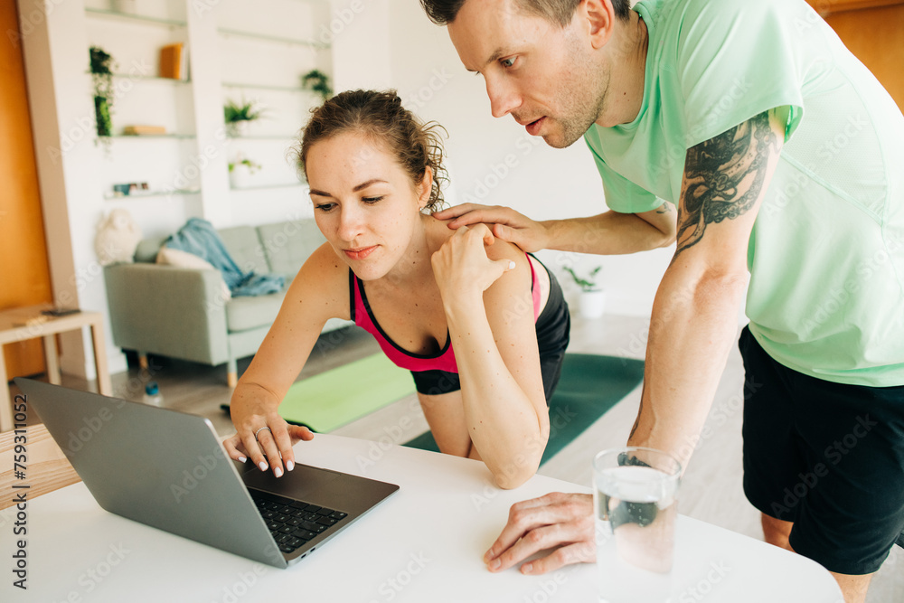 Couple in sportswear using laptop Couple in sportswear using laptop
