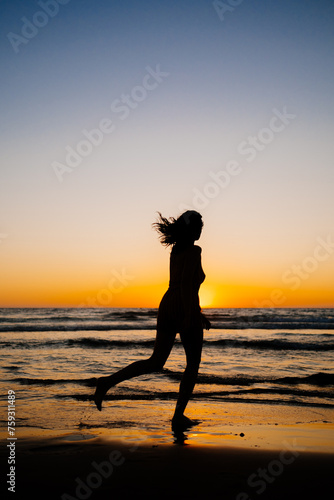 Silhouette of an attractive girl on a beautiful sea sunset photo