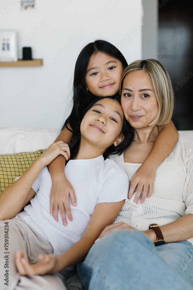 Two girls with their mother sitting on the sofa Two girls with their mother sitting on the sofa