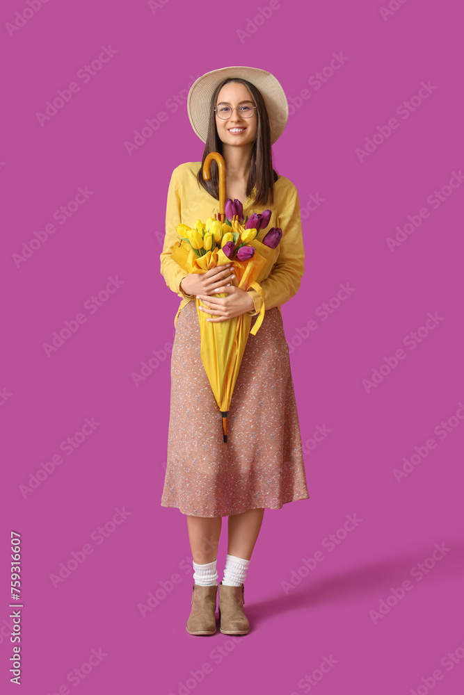 Young woman holding umbrella with tulips on purple background