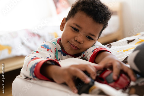 Toddler playing on top of the bed photo